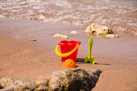 塑料沙滩玩具靠近水.孩子们在海边度假的乐趣.海滩上的游戏.