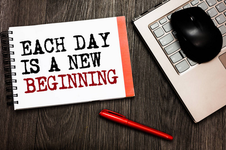 概念性的手工书写显示每一天是一个新的开始。商业照片展示每天早上你可以重新开始灵感蓝牙鼠标在键盘上的单词红色钢笔在木甲板上