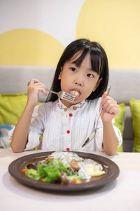亚洲小中国女孩在餐厅吃西餐
