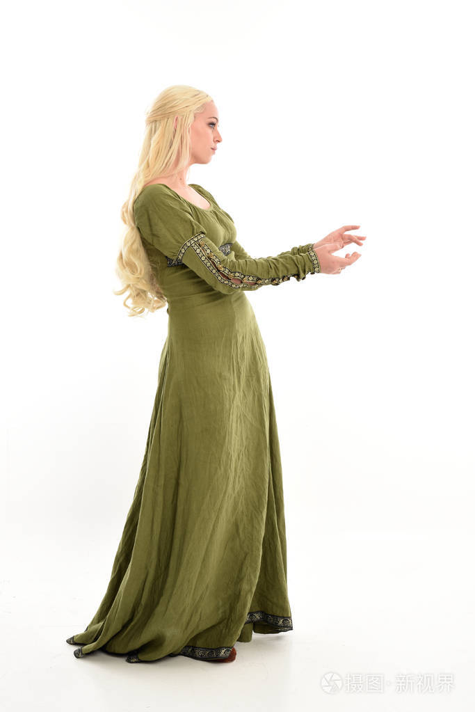 穿绿色中世纪礼服的女孩全长肖像, 站立姿势在侧面轮廓.