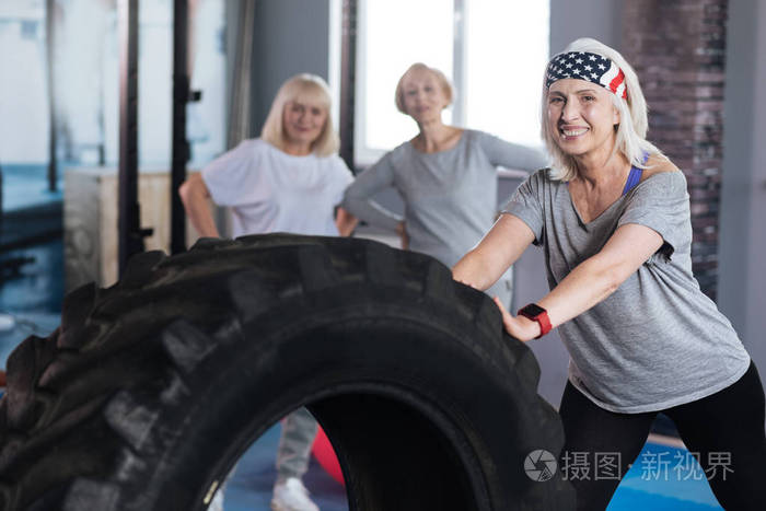 好坚强的女人站在一个巨大的轮胎