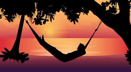 上海滩日出躺在吊床上海滩度假的人剪影照片
