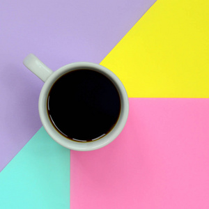 小白咖啡杯的纹理背景的时尚粉彩蓝色, 黄色, 紫罗兰色和粉红色的纸张在极小的概念
