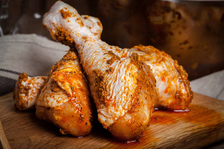 在木砧板上腌好的鸡肉鸡腿照片