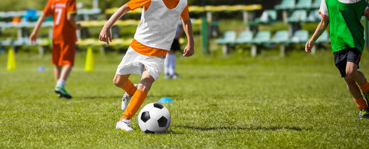 孩子们的足球足球比赛。孩子足球球队训练比赛场上。男孩跑和踢足球球。青少年足球足球比赛