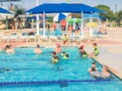 模糊的孩子和他们的父母在社区室外游泳池享受游泳和水活动。健康的生活方式, 主动的父母, 游泳课活动, 家庭假期在水生中心