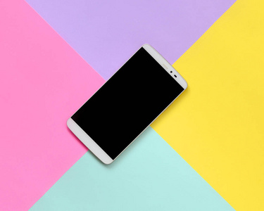 现代智能手机与黑色屏幕的纹理背景的时尚粉彩蓝色, 黄色, 紫罗兰色和粉红色的纸张在极小的概念