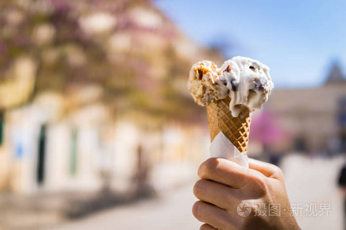 女手拿着在夏天意大利融化美味的冰淇淋