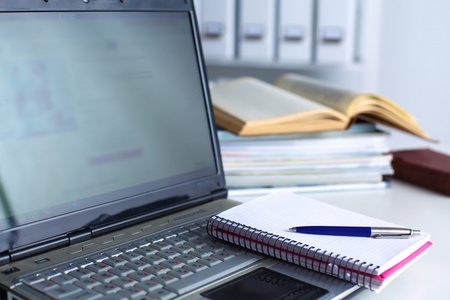 在白色背景上的文件夹堆栈的文件夹在白色背景上桌上的笔记本电脑照片