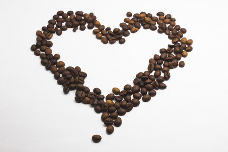 白色背景上孤立的心形状咖啡豆图片