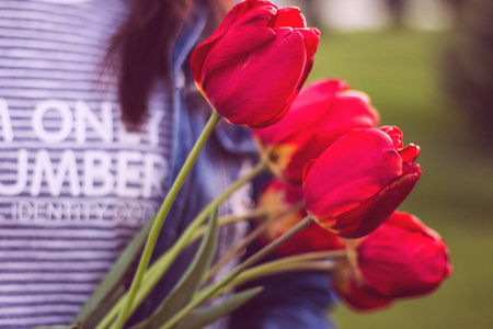 年轻的女孩的郁金香花束，走在公园