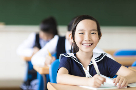 快乐的小女孩,在学校和她的朋友在背景中照片