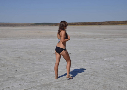 女孩站在干涸的湖底的咸水湖图片