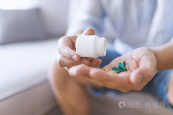 男人用药丸把药片从瓶子里泼出来.医药保健理念.