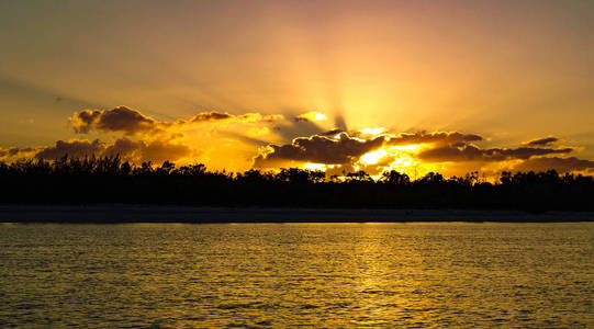 一个引人注目的鼓舞人心的金色多云日出海景以大胆的黄昏射线 太阳光束 在海洋水与水的反射