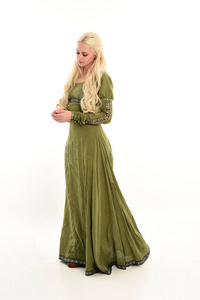 穿绿色中世纪礼服的女孩全长肖像, 站立姿势在侧面轮廓。在白色工作室背景下被隔离