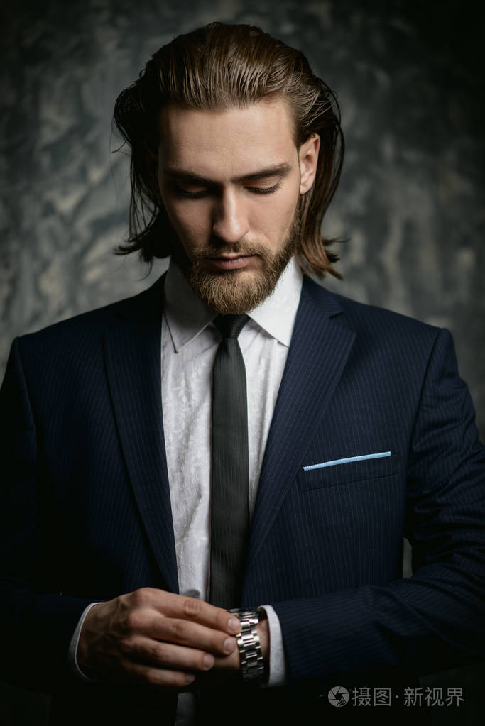 时尚镜头英俊的年轻人穿着优雅的西装, 在黑暗的背景.男士美容, 时尚