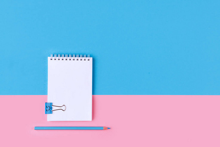 彩色背景粉红色蓝色与复制空间的空白笔记本的顶部视图