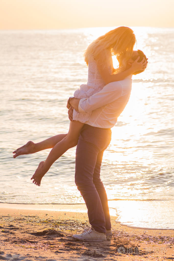 美丽年轻的浪漫情侣接吻在海边在 ri 的光线