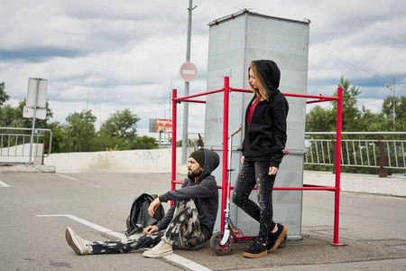 年轻时尚夫妇与踢滑板车在城市背景