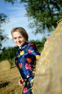 在波兰农场假扮的乌克兰女性模特。年轻女子穿着五颜六色的礼服站在干草包旁边