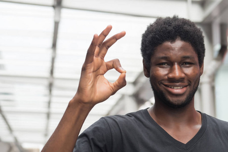 成功的非洲人指向 ok 或好手标志;快乐的微笑非洲人或黑人指出批准