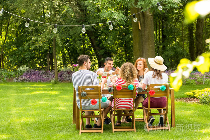 一群微笑的朋友在夏天享受户外生日聚会照片-正版商用图片0pvghc-摄图