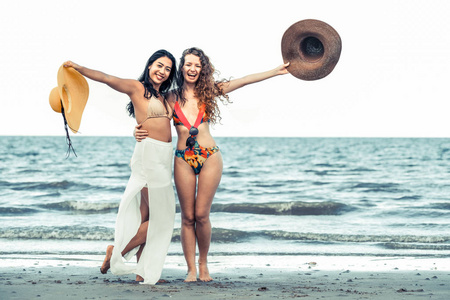 夏天假期, 在热带沙滩上, 穿着比基尼的快乐女人一起跳舞。旅游生活方式