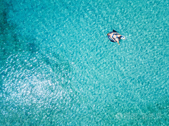 漂浮在绿松石海的水床垫上的女人的鸟瞰图