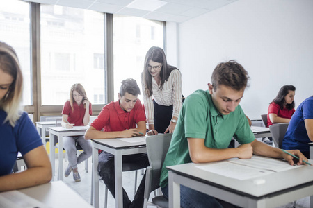 一名女教师在考试中帮助学生照片