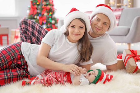 幸福夫妇与婴孩在圣诞节帽子在家