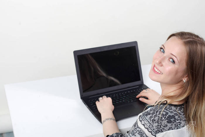 女人坐在办公桌前的笔记本电脑