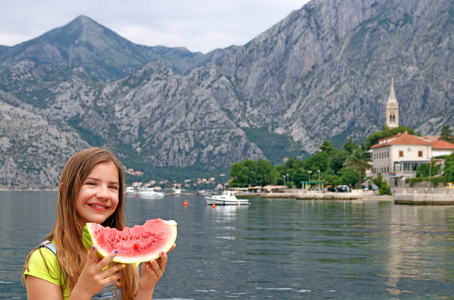 愉快的小女孩与西瓜在夏天假期 Kotor 海湾