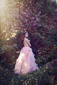 穿着粉红色连衣裙的女孩在花园里