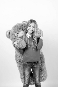 女孩拥抱大泰迪熊在橙色背景