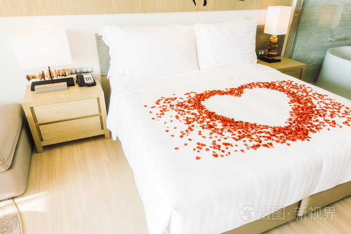 在床上和玫瑰花瓣上的白色枕头
