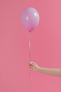 裁剪视图的妇女持有单一粉红色气球孤立粉红色