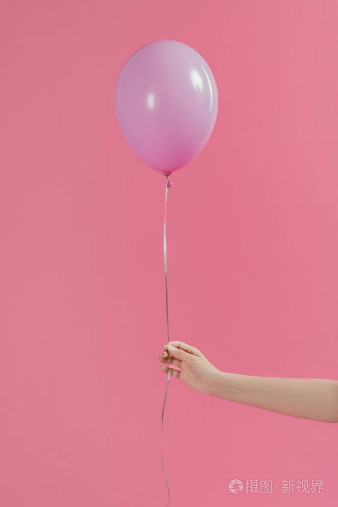 裁剪视图的妇女持有单一粉色气球孤立粉色