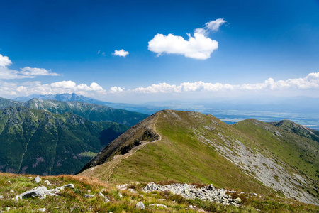 沿着山地小径远足。获得山峰。两个人在山顶欣赏风景