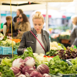 在当地的食品市场的菜市场买菜的女人照片
