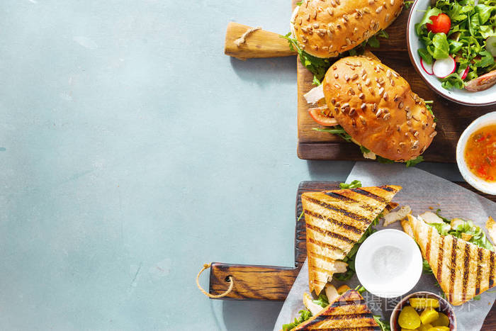 烤三明治与掘金, 沙拉, 酱汁和腌黄瓜在蓝色背景与复制空间, 顶部视图