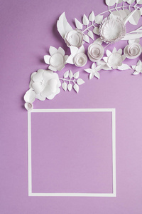 用白色纸花紫罗兰色背景上的方框。由纸剪成