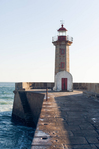 美丽的老灯塔附近海洋在晴朗的一天