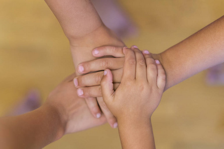 儿童友谊与互助的概念。孩子们的双手堆积在一起。儿童双手堆积