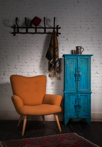 复古橙色扶手椅 蓝色柜子，墙衣架和黑色围巾
