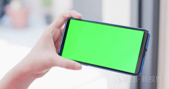 手持绿屏手机的妇女