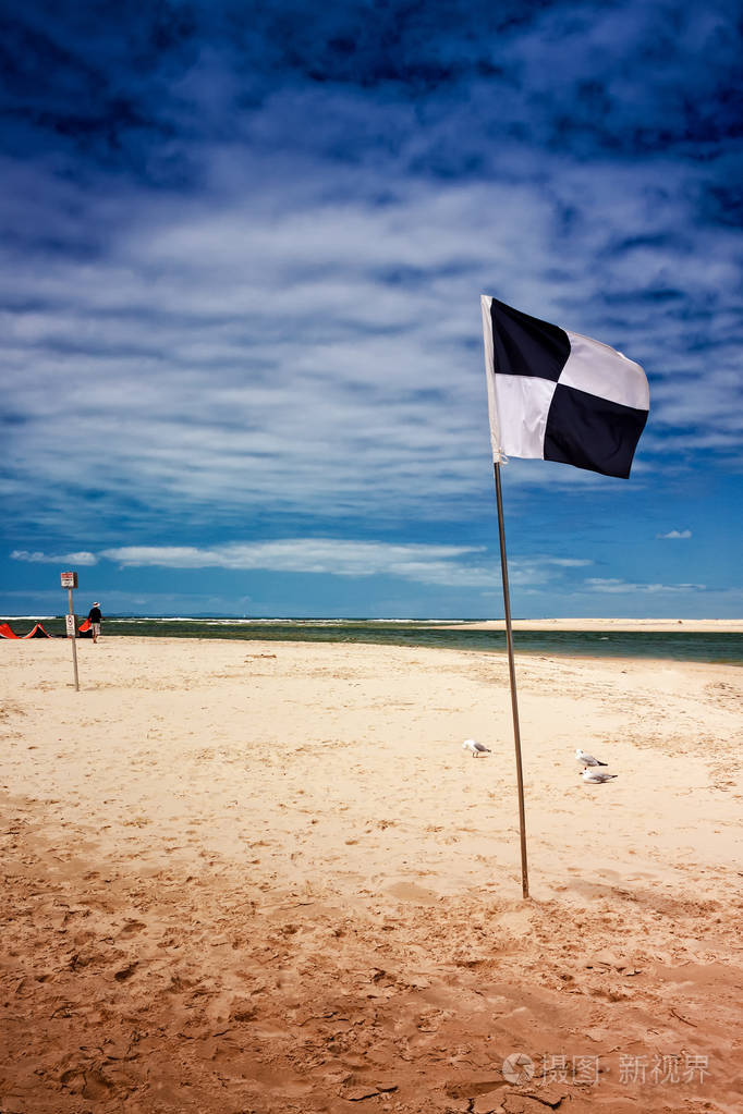 在澳大利亚昆士兰墨尔本的海滩上, 一只黑白相间的旗帜标示着冲浪区.