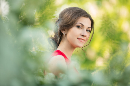 美丽年轻的黑发女人站附近白花盛开