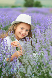 孩子女孩在薰衣草领域, 美丽的肖像, 面孔特写, 夏天风景