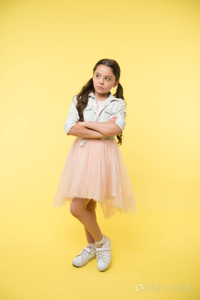 时装模特代理为孩子.孩子在黄色的背景上保持双臂交叉.